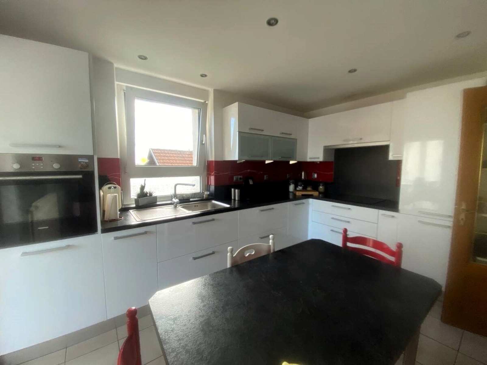 Cuisine d'un logement en location courte durée avant optimisation : lumière plate et blancs ternes