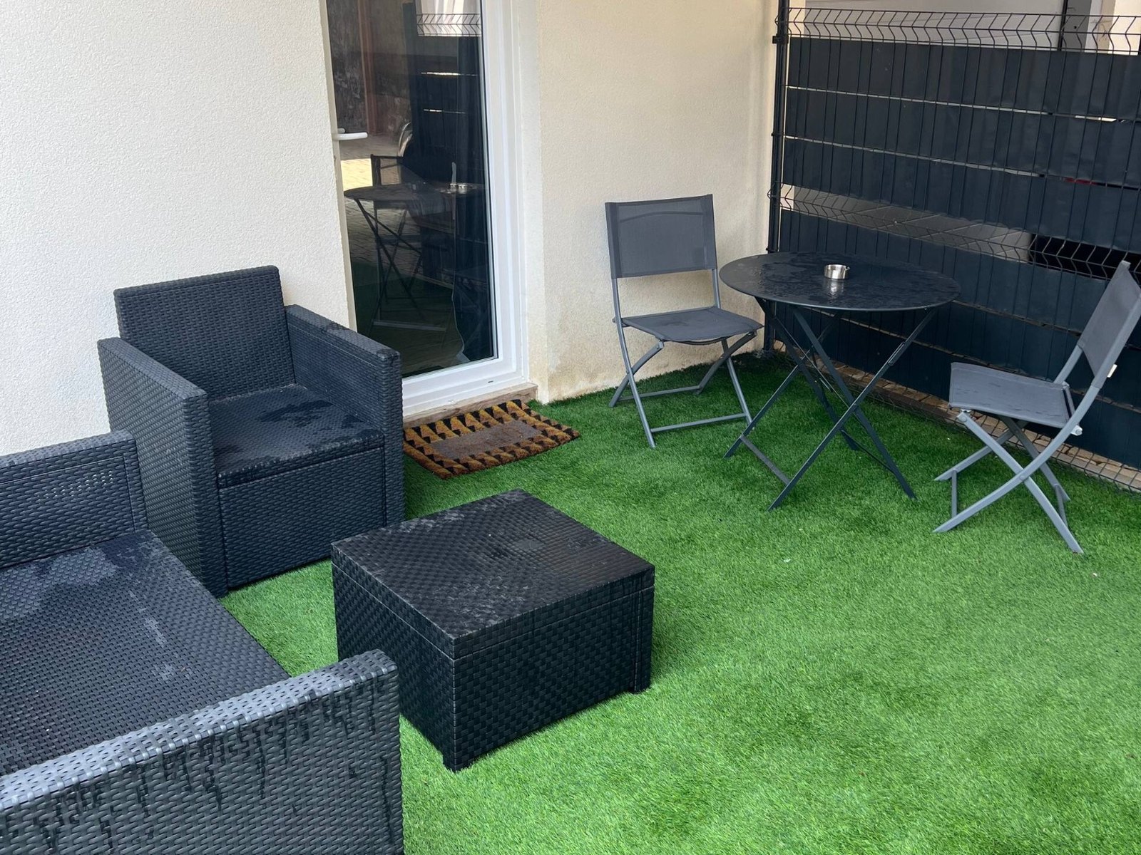 Terrasse d'un hébergement touristique avant optimisation : mobilier mouillé, scène peu engageante